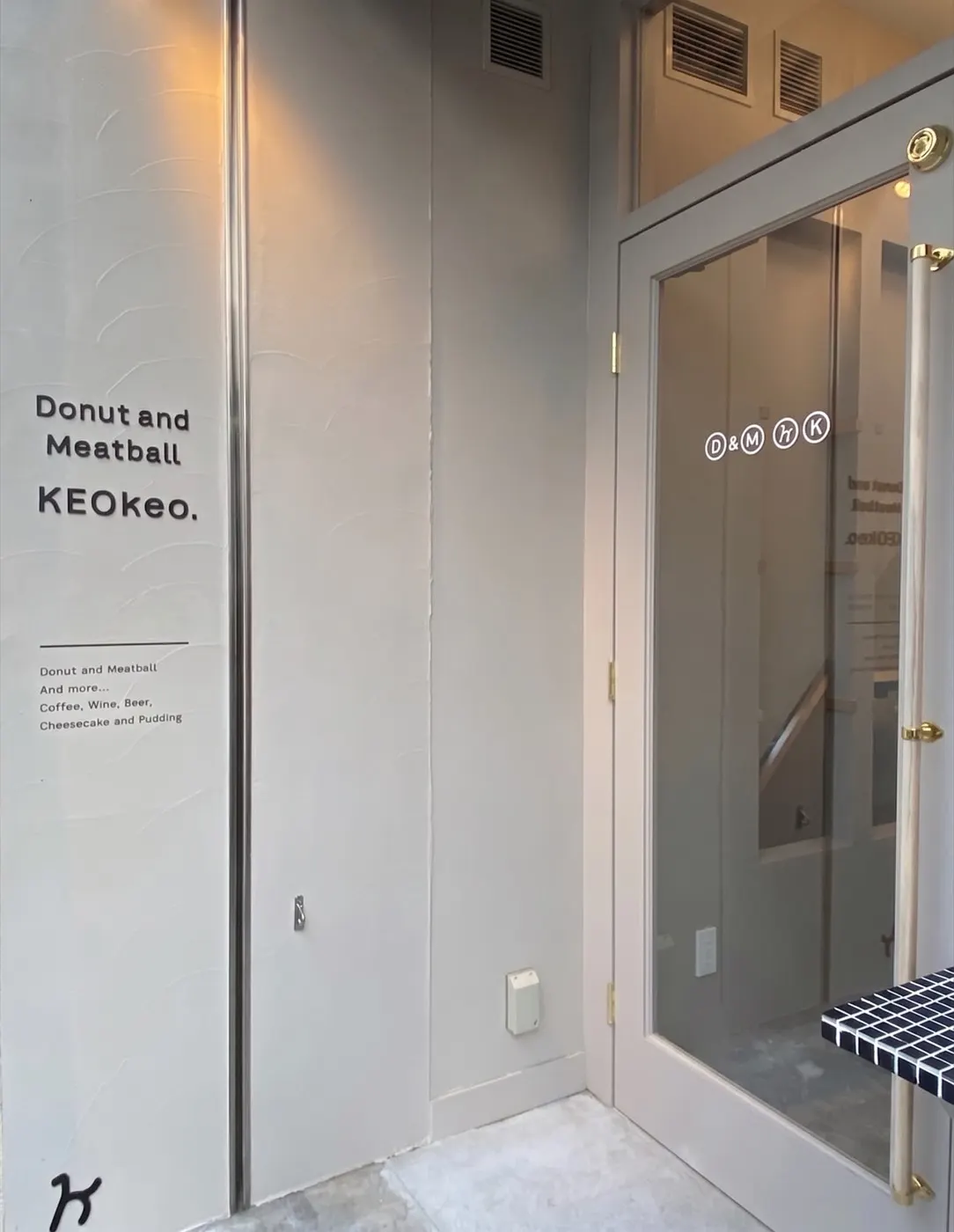 Donut and Meatball KEOkeo. の入り口。白い壁のサインとガラスドア